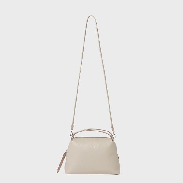 The GIANNI CHIARINI ALIFA crossbody bag made in Italian beige leather features a minimalist design, adjustable straps, short handles, and a zippered top.